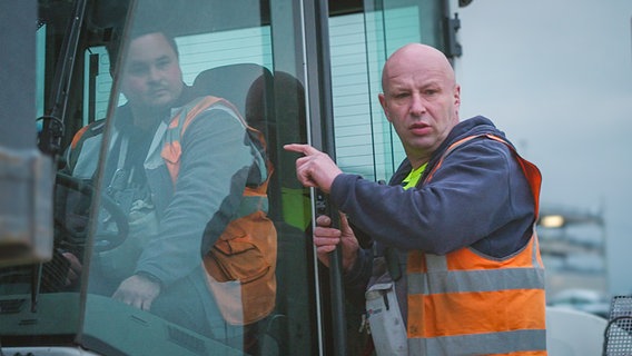 Pannenhelfer Deev Wiebusch spricht mit einem Kollegen. © NDR/FILMBLICK Hannover/Martin Göbel 