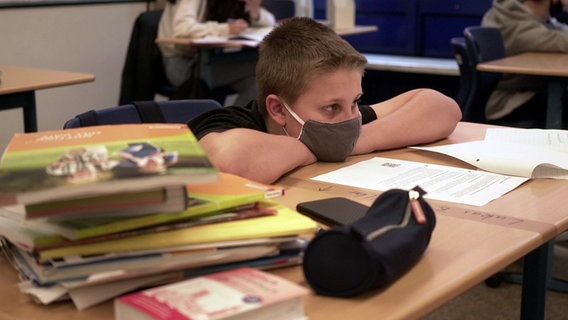 Boy with a respirator has put his upper body on a table.  © NDR 