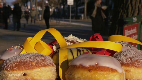 Several Berliners lie on a tray.  