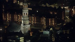 Die beleuchtete Speicherstadt aus der Vogelperspektive bei Nacht, im Vordergrund des Bildes sieht man die Katharinenkirche.