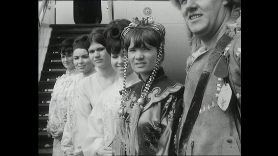 Kostümierte empfangen am Flughafen Hamburg-Fuhlsbüttel Premierengäste für den Spielfilm "Dschingis Khan" (1965)  