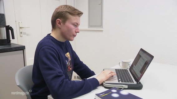 Student Hennis Herbst is sitting at a laptop.  