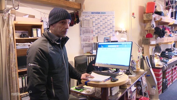 Eike Peters stands in front of a PC monitor in his Wismar sailing store.  