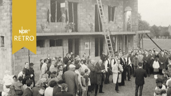 Arbeiter und Gäste vor einem Gebäude beim Richtfest (1965)  