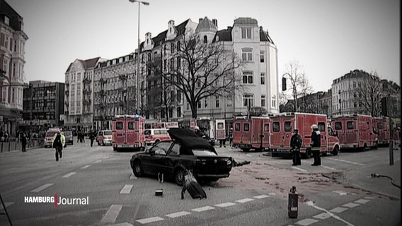 Blick auf die Kreuzung auf der sich der Unfall 2011 in Eppendorf abspielte. Zu sehen ist ein verunglückter Pkw und zahlreiche Rettungsfahrzeuge, die drum herum stehen. In dem Bild wurden die Grautöne hervorgehoben.  