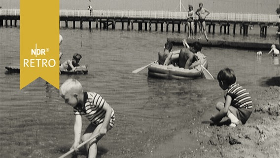Kinder beim Spielen am Ostseestrand der Flensburger Förde im Sommer 1964  