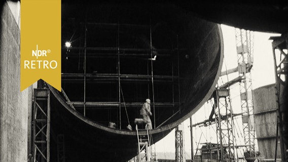 Arbeiter läuft wie im Hamsterrad in der großen Röhre eines Windkanals im Bau 1964  