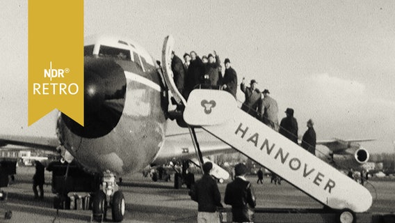 Musiker der Berliner Philharmoniker winken von der Gangway am Flughafen Hannover (1965) vor dem Abflug nach New York  