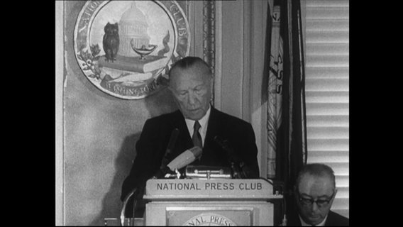 Konrad Adenauer an einem Redepult.  