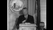 Konrad Adenauer an einem Redepult.  