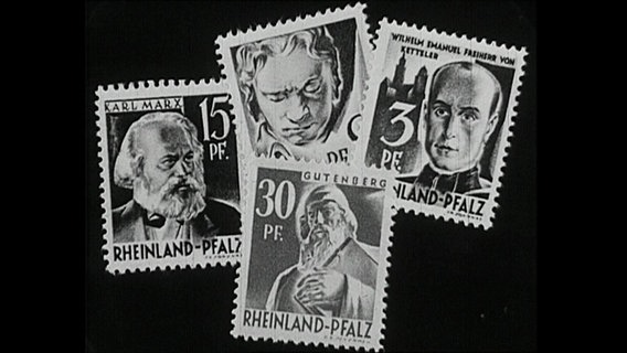 Verschiedene historische Briefmarken auf schwarzem Grund.  