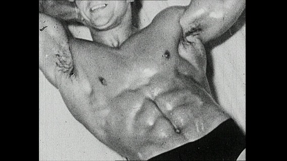 Ein Bodybuilder präsentiert seinen durchtrainierten Bauch.  