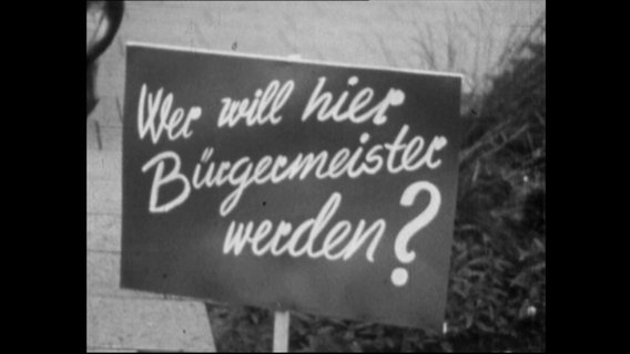 Ein Plakat mit der Aufschrift "Wer will Bürgermeister werden?"  