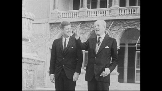 Der US-Präsident John F. Kennedy geht mit Großbritanniens Premierminister Macmillan eine Treppe herunter.  
