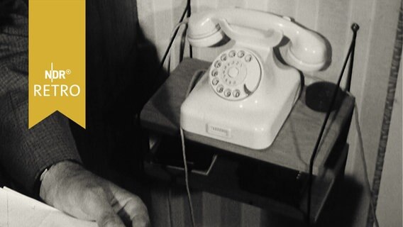 Ein Wähltelefon auf einem Telefontischchen 1963  