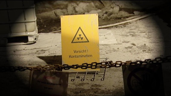 Ein gelbes Schild mit der Aufschrift "Vorsicht Kontamination"  