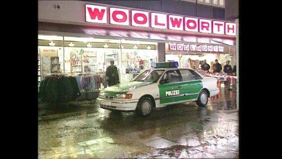 Ein Polizeiauto steht vor einer Woolworth-Filiale (Archivbild).  