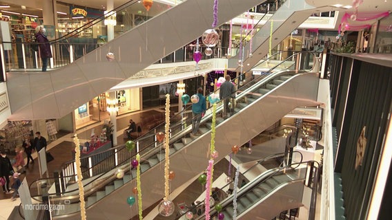 View of the escalators of the Schwerin shopping center on which there are occasional people.  