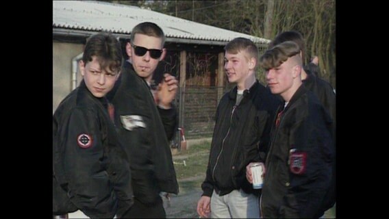 Fünf Skinheads mit schwarzen Jacken unterhalten sich (Archivbild).  