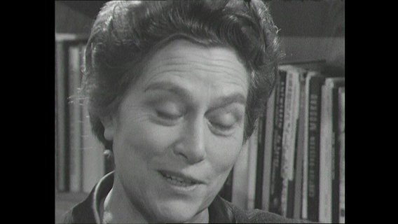 Grete Nevermann im Interview 1963 vor der heimischen Bücherwand  