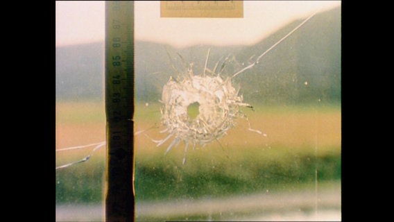 Ein Einschussloch in einem Fenster  