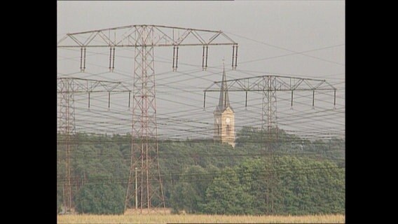 Strommasten stehen auf einem Feld.  