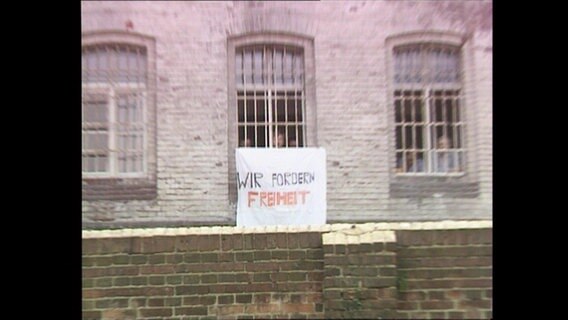 Aus einem Gitterfenster einer DDR-Psychiatrie hängt das Banner "Wir fordern Freiheit" (Archivbild).  