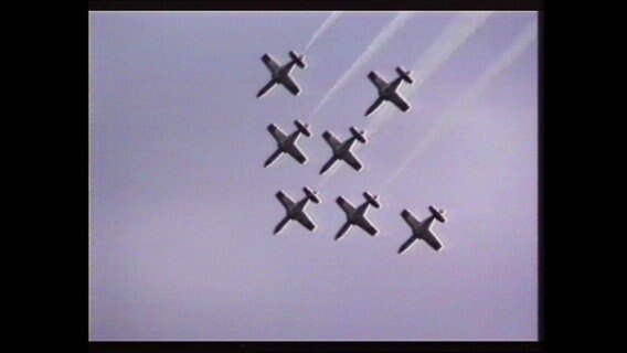 Sechs Flugzeuge fliegen in einer Formation.  