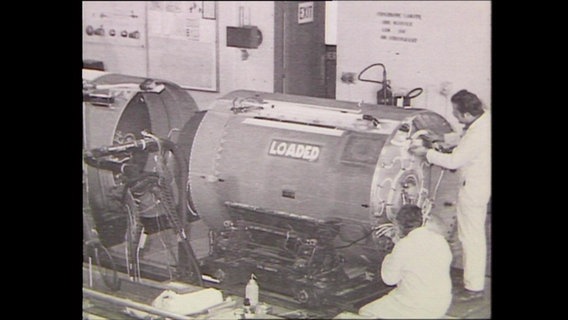 Zwei Männer in Schutzanuügen arbeiten an einem Kessel in einer Kernwaffenfabrik (Archivbild).  