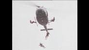 Einsatzkräfte der Sondereinheit GSG9 seilen sich aus einem Hubschrauber in der Luft ab (Archivbild).  