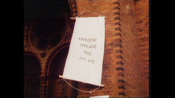 An einer Kirche hängt das Banner "Friedens-Dekade"  