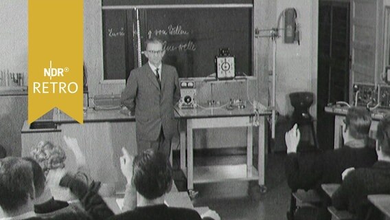 Physiklehrer vor einer Tafel im Unterricht einer Oberstufenklasse 1963  