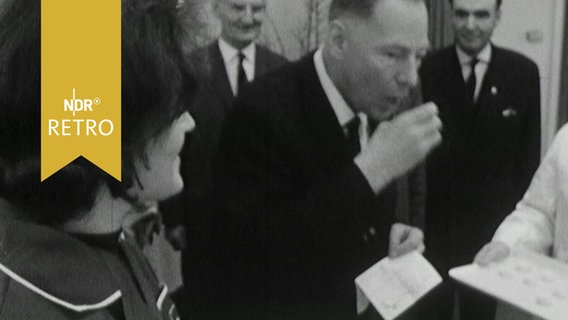 Helmut Lemke, Ministerpräsident von Schleswig-Holstein, nimmt ein Glas mit einer Schluckimpfung im Rahmen der Massenimpfung gegen Polio 1964  