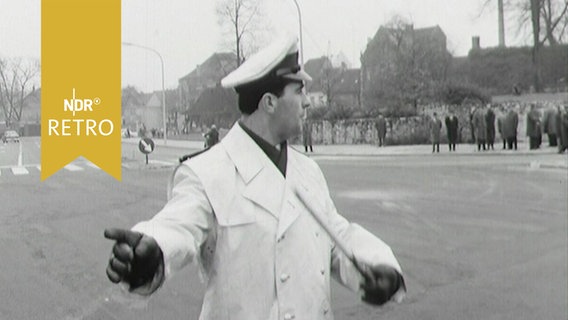 Verkehrspolizist regeld den Verkehr auf einer großen leeren Kreuzung in Osnabrück 1963  