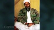 Osama bin Laden sitzt auf dem Boden  
