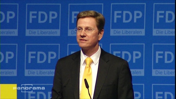 Guido Westerwelle vor einem Mikrofon  