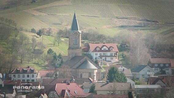 Ein Kirchturm in einem Dorf  