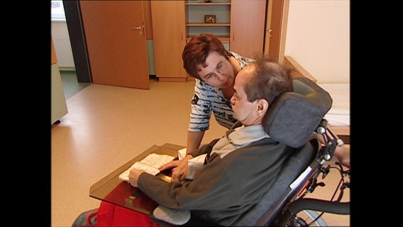 Inge Heissenberger am Rollstuhl ihres Mannes  
