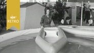 Frau präsentiert ein Faltboot auf einer Campingausstellung in Hamburg 1964  