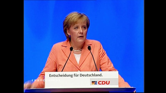 Angela Merkel an einem Rednerpult  