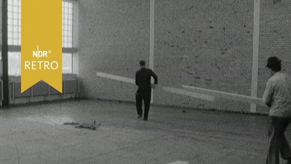 Arbeiter tragen Balken in einer neuen Schul-Turnhalle (1964)  