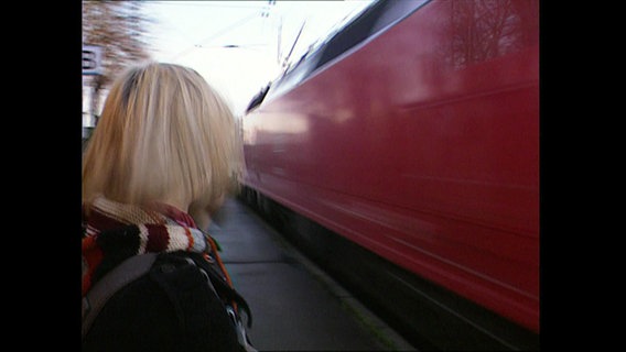 Eine Frau auf dem Bahnsteig  