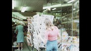Eine Frau an einem Zeitungsständer (Archivbild)  