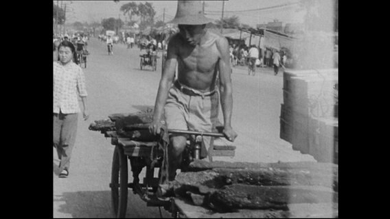 Ein Mann fährt Fahrrad auf einer chinesischen Straße (Archivbild)  