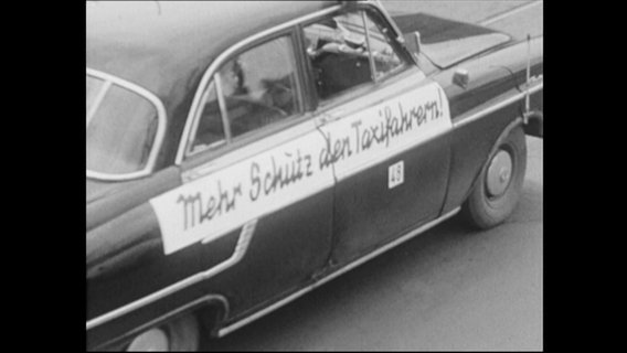 Aufschrift "Mehr Schutz den Taxifahrern" auf einem Auto (Archivbild)  