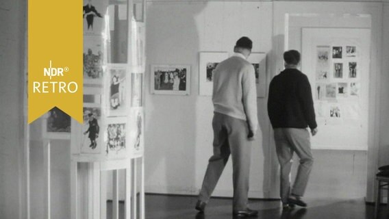 Besucher in einer Ausstellung von Karikaturen Rudolf Wilkes in Hannover (1964)  