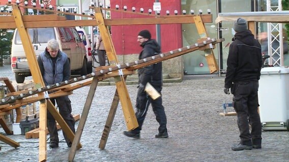 Männer beim Abbau des Greifswalder Weihnachtsmarktes. © Screenshot 