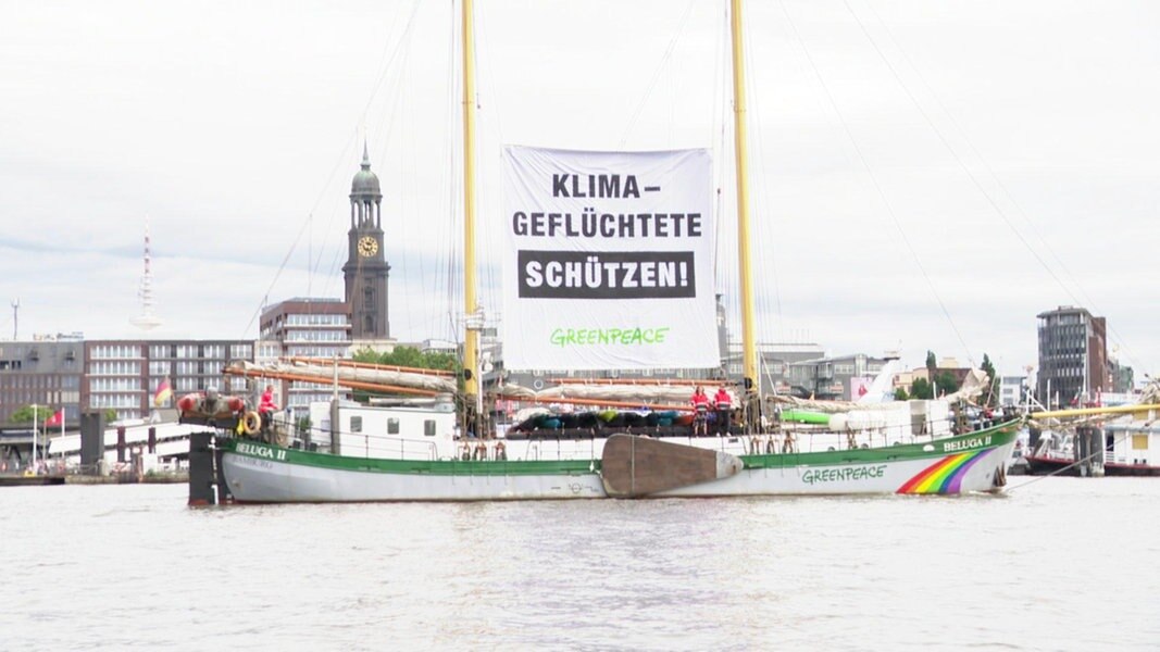 Ein Greenpeace-Schiff mit Transparent 