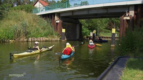 Paddler auf dem Wasser vor einer Schleuse. © Screenshot 