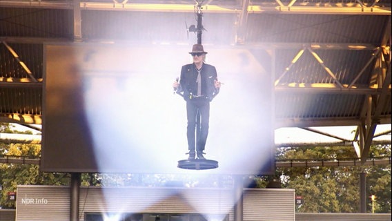 Udo Lindenberg auf einer schwebenden Bühne während eines Konzerts. © Screenshot 